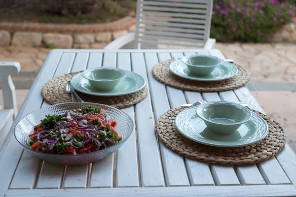 Table for three with salad plate in garden