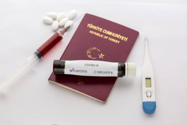 Şırınga, termometre ve haplı Türk pasaportu üzerinde Covid-19 testi sonucu