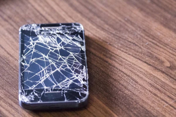 Phone screen broken, on wooden floor