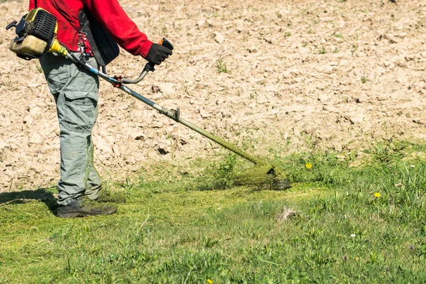 Работник с электрическим инструментом стринга газона триммер — стоковое фото