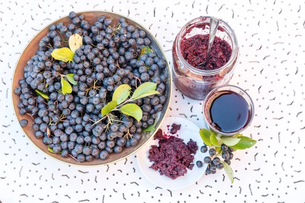 Zumo fresco y mermelada de chokeberry negro (Aronia melanocarpa) en vaso y baya en maceta — Foto de Stock