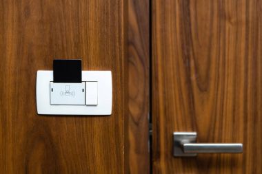 Otel Oda kapı ve ışık anahtarı closeup. Anahtar kartı elektronik kilit ahşap duvar