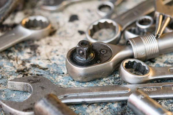 Closeup of ratchet wrench and open end wrench on table in garage. Workshop mechanic concept.