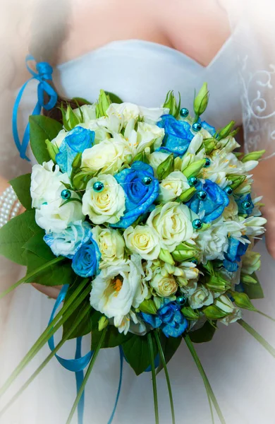 Bruiloft blauwe en witte bloemen in handen van de bruid in trouwdag — Stockfoto