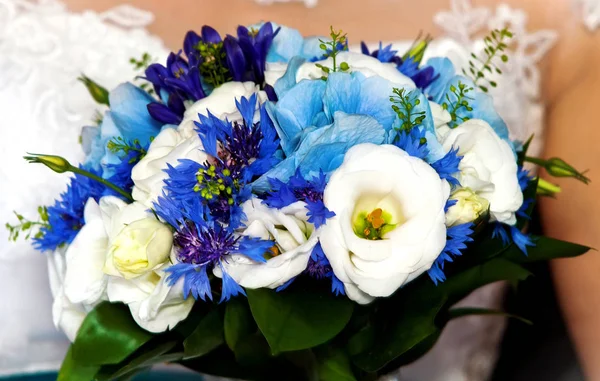 Bruiloft blauwe en witte bloemen in handen van de bruid in trouwdag — Stockfoto