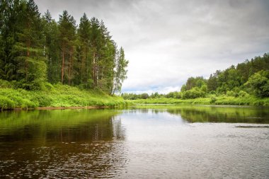 Bulutlu bir günde Nehri üzerindeki kırsal manzara yaz
