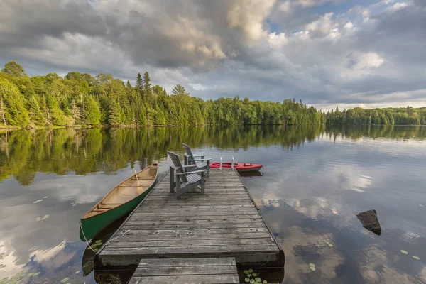 Canoa e caiaque amarrado a uma doca em um lago em Ontário Canadá — Fotografia de Stock