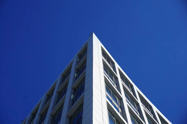 Clădire modernă cu ferestre izolate pe fundal albastru . — Fotografie, imagine de stoc