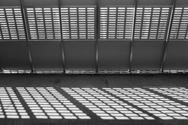 Gölge ve ışık. Siyah ve beyaz. Güneşli gün ışığı terk edilmiş tamamlanmamış shoping alışveriş merkezinde metal kafes üzerinden