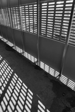Gölge ve ışık. Siyah ve beyaz. Güneşli gün ışığı terk edilmiş tamamlanmamış shoping alışveriş merkezinde metal kafes üzerinden