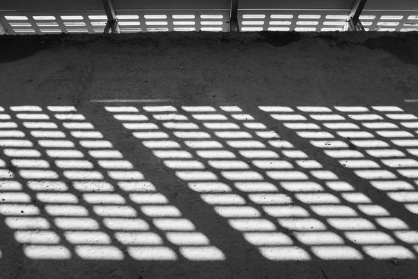 Sombra e luz. Preto e branco. Luz do dia ensolarada da rede de metal no shopping center inacabado abandonado — Fotografia de Stock