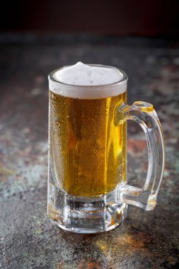 Eski bir arka planda, bardakta hafif bira..