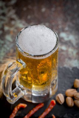 Eski bir arka planda, bardakta hafif bira..