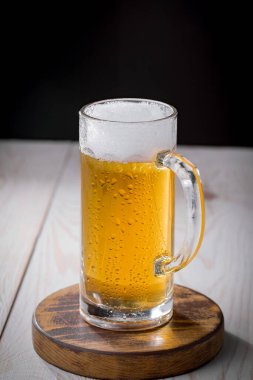 Eski bir arka planda, bardakta hafif bira.