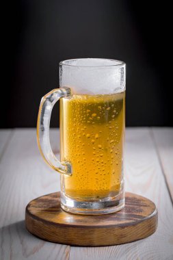 Eski bir arka planda, bardakta hafif bira.