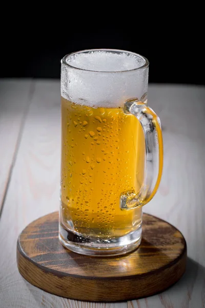 Light beer in a glass on an old background.