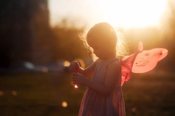 Kleines Mädchen Spielt Mit Seifenblasen Auf Einer Lichtung Bei Sonnenuntergang — Stockfoto