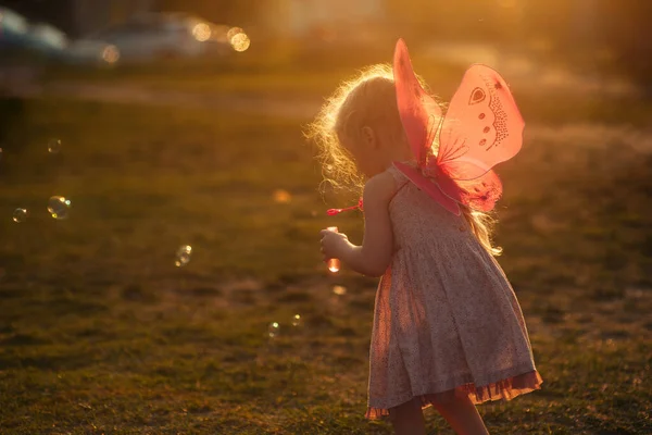 Kleines Mädchen Spielt Mit Seifenblasen Auf Einer Lichtung Bei Sonnenuntergang — Stockfoto