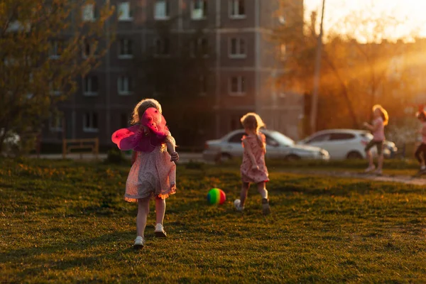 两个姐姐在黄昏时分 拿着球和跳绳在操场上玩耍 — 图库照片