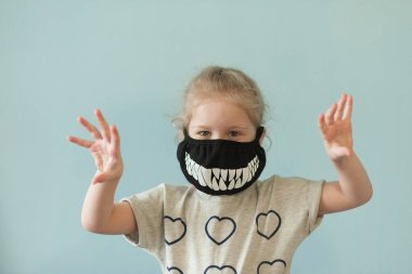 little girl in a black protective mask on which white teeth are painted clipart