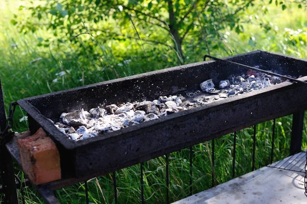 charcoal grill on nature. The ashes from the coals on the grill scatter