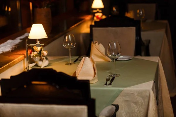 Bicchieri, forchetta da fiori, coltello servito per cena in ristorante con interni accoglienti — Foto Stock