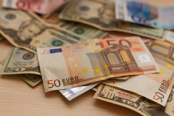 Cash dollars liggend op het vliegtuig en de euro de tabel — Stockfoto