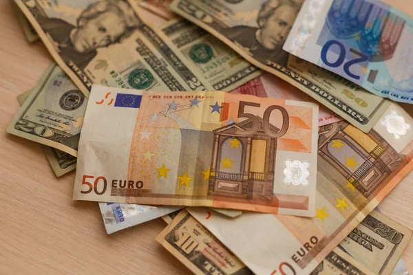 Cash dollars liggend op het vliegtuig en de euro de tabel — Stockfoto