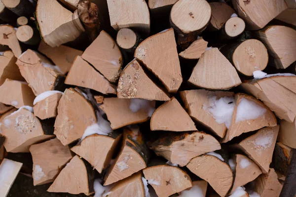 Achtergrond van droge gehakte brandhout logt stapel met sneeuw — Stockfoto