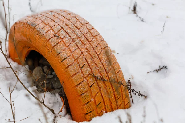 Neumático en la nieve Neumático naranja en la —  Fotos de Stock