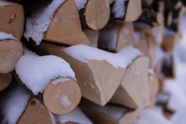 Fußabdrücke im Schnee in der Nähe eines Kaminholzstapels — Stockfoto