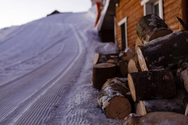 Voetstappen in de sneeuw in de buurt van een stapel brandhout — Stockfoto