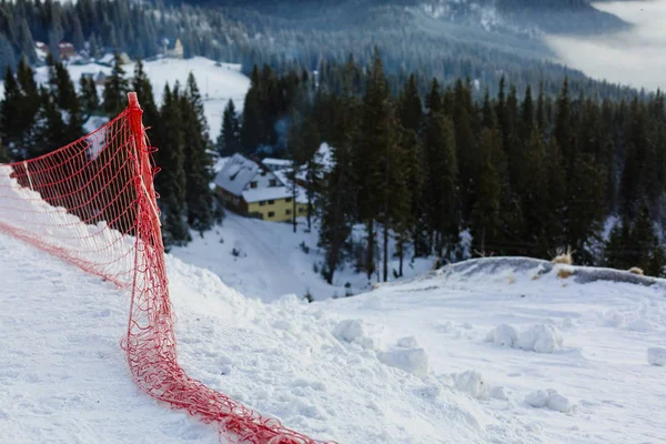 Vista da pista de esqui coberta de neve nas montanhas. Na lateral estão instaladas redes de segurança. Dia ensolarado . — Fotografia de Stock