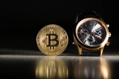 Siyah arka plan üzerine saatler bitcoin ile yakın çekim
