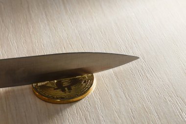 Bir altın sikke bitcoin üzerinde bir bıçak bıçak