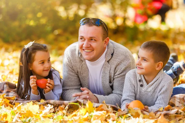 Bir sonbahar gününde bir parkta sevimli aile — Stok fotoğraf