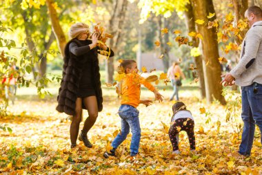 Sonbahar parkında iki çocuklu bir aile 