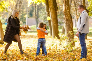 Sonbahar parkında iki çocuklu bir aile 