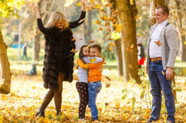 Sonbahar parkında iki çocuklu bir aile 