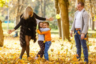 Sonbahar parkında iki çocuklu bir aile 