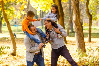 Sonbahar parkında çocuklu babalar