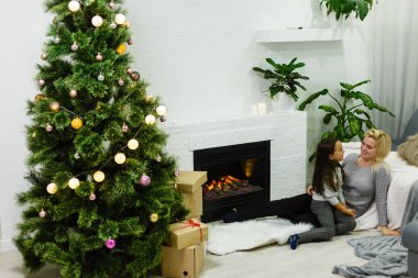 Anne ve kızı Noel 'de birlikte mutlular. Noel, Noel, kış, mutluluk konsepti - anne ve kız. Noel 'de aile. Noel 'i bekliyorum. Tatil İçi 