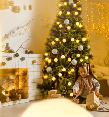 Mutlu bir Noel atmosferiyle odada oynayan kız.