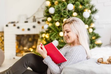 Güzel genç bir kadın Noel ağacıyla evde.