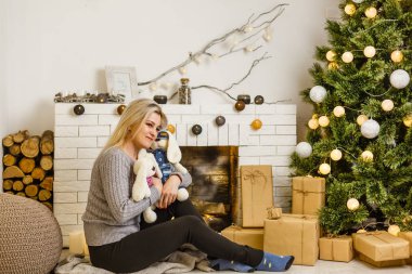 Güzel genç bir kadın Noel ağacıyla evde.