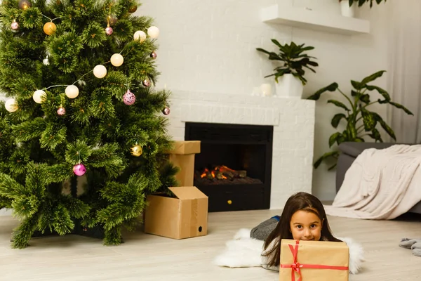 Entzückendes Kleines Mädchen Liegt Heiligabend Unter Dem Weihnachtsbaum Kamin — Stockfoto
