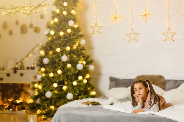Kleines Mädchen Liegt Auf Einem Bett Einem Weihnachtlich Dekorierten Zimmer — Stockfoto
