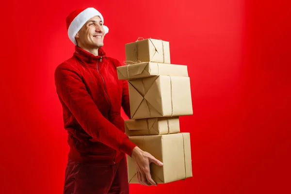 サンタクロースは彼の手に多くの贈り物を運ぶ — ストック写真