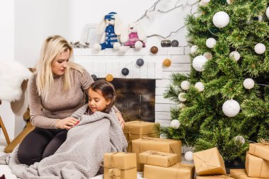 Mutlu Noeller ve mutlu tatiller. Evde Noel ağacının yanında aile hazırlığı