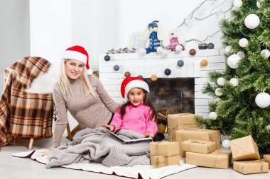 Mutlu Noeller ve mutlu tatiller. Evde Noel ağacının yanında aile hazırlığı